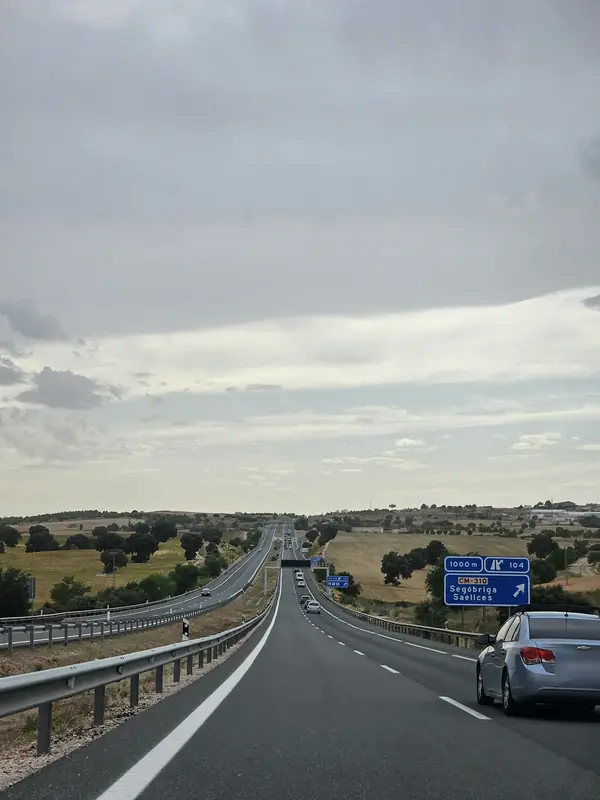 Autovía española con un cartel azul que anuncia la próxima salida